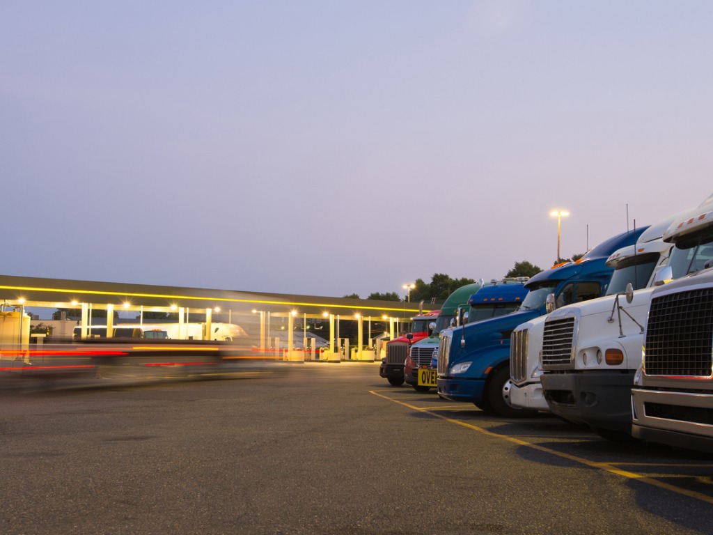 evening-truck-stop-lights-of-number-of-trucks-in-parking-picture-id514852941
